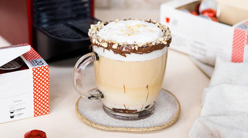 Xícara de café com chocolate cremoso, com as bordas cobertas de chocolate e chantilly.